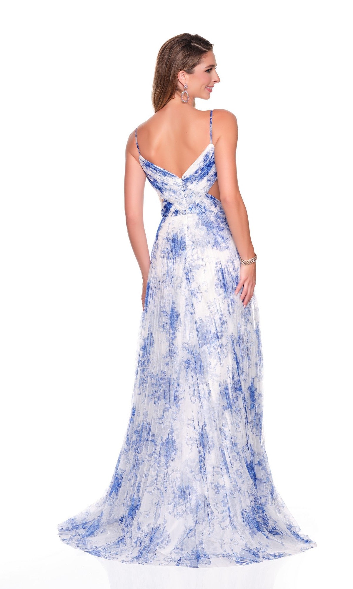 A woman models the Dave and Johnny 12938 long prom dress, a sleeveless white chiffon A-line gown with blue floral patterns, open back, and thin straps, posing against a white background.